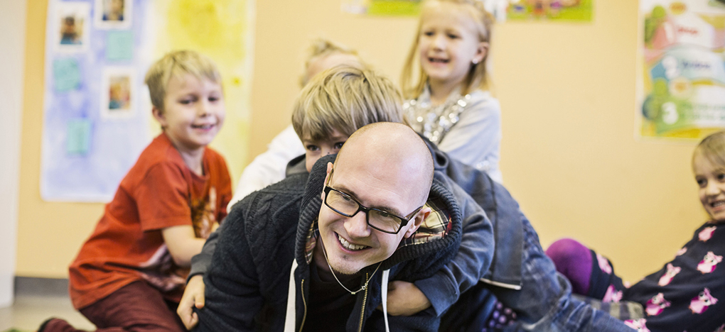 Foto: Ein Erzieher tobt mit Kita-Kindern