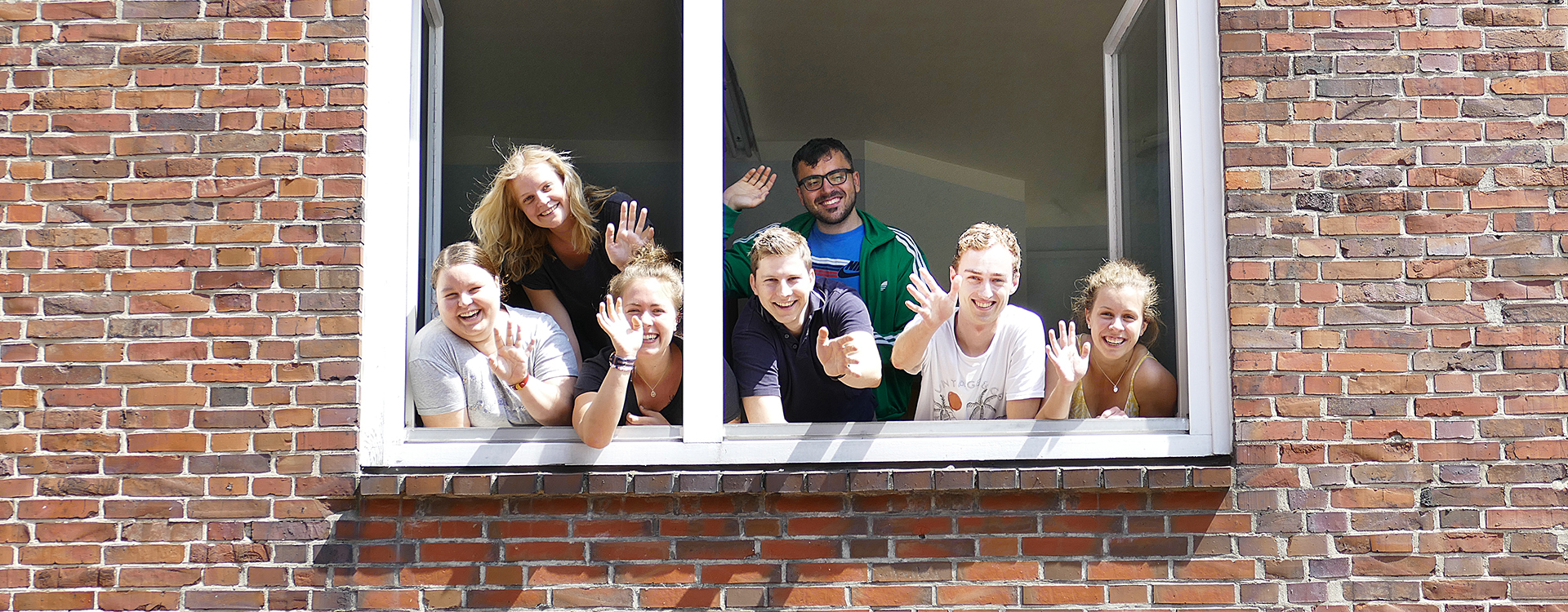 Foto: Studierende schauen aus dem Fenster des Wohnheims